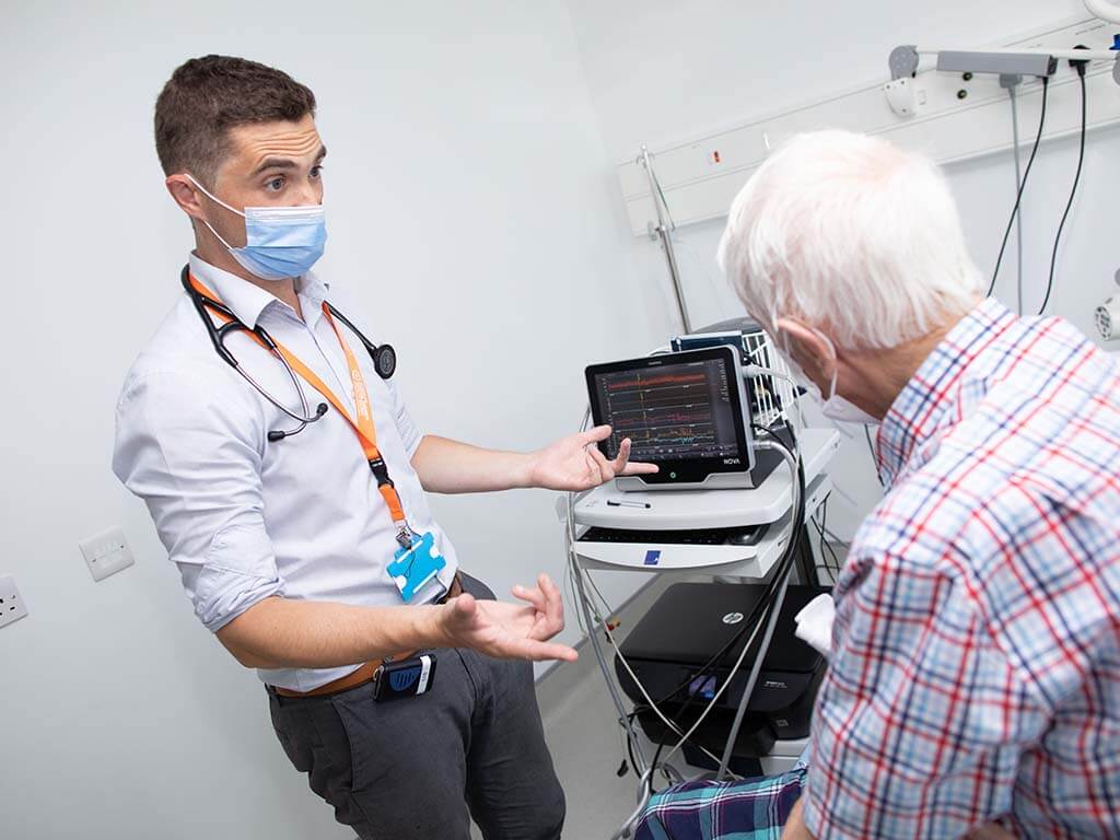 Doctor performs examination and speaks with elderly patient